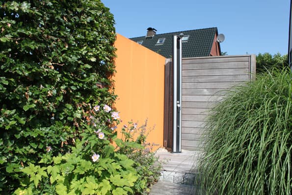 Gartenzugang mit modernem Sichtschutzzaun und begrünter Wand