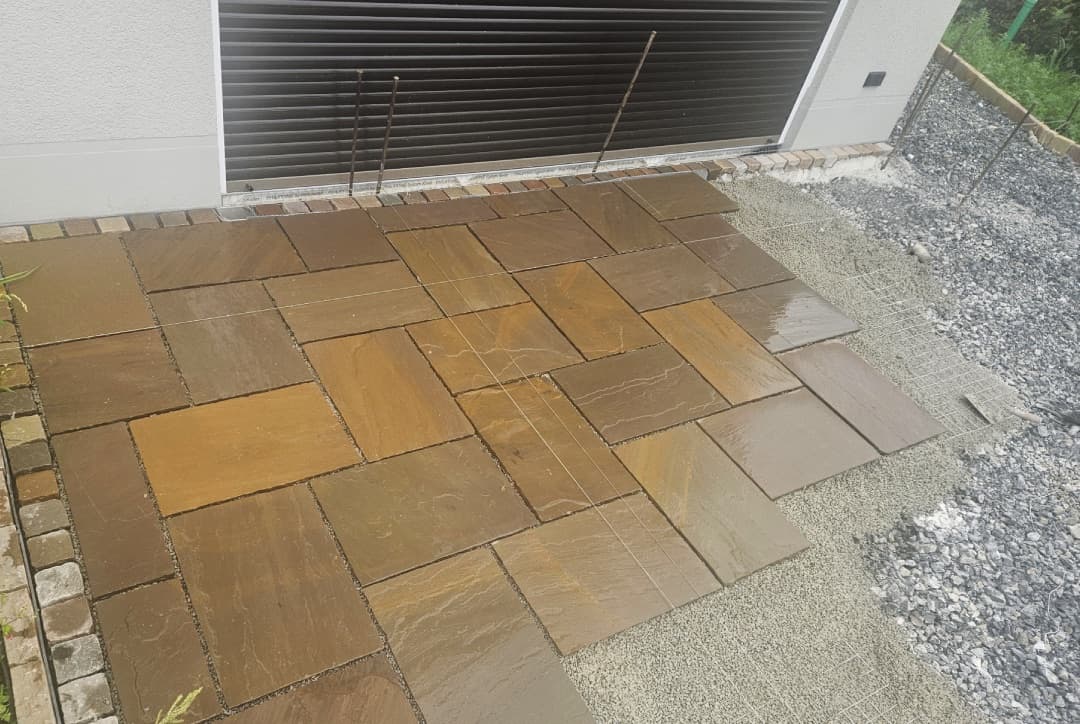 Sandstein-Terrassenplatten in Verlegung vor der Garage